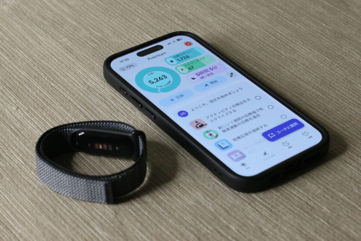 Google Fitbit Air本体と、iPhoneに表示されたGoogle Health Premiumのダッシュボード。歩数・消費カロリー・エナジースコア・睡眠データを一画面で確認できる（撮影：スマブロ.com）